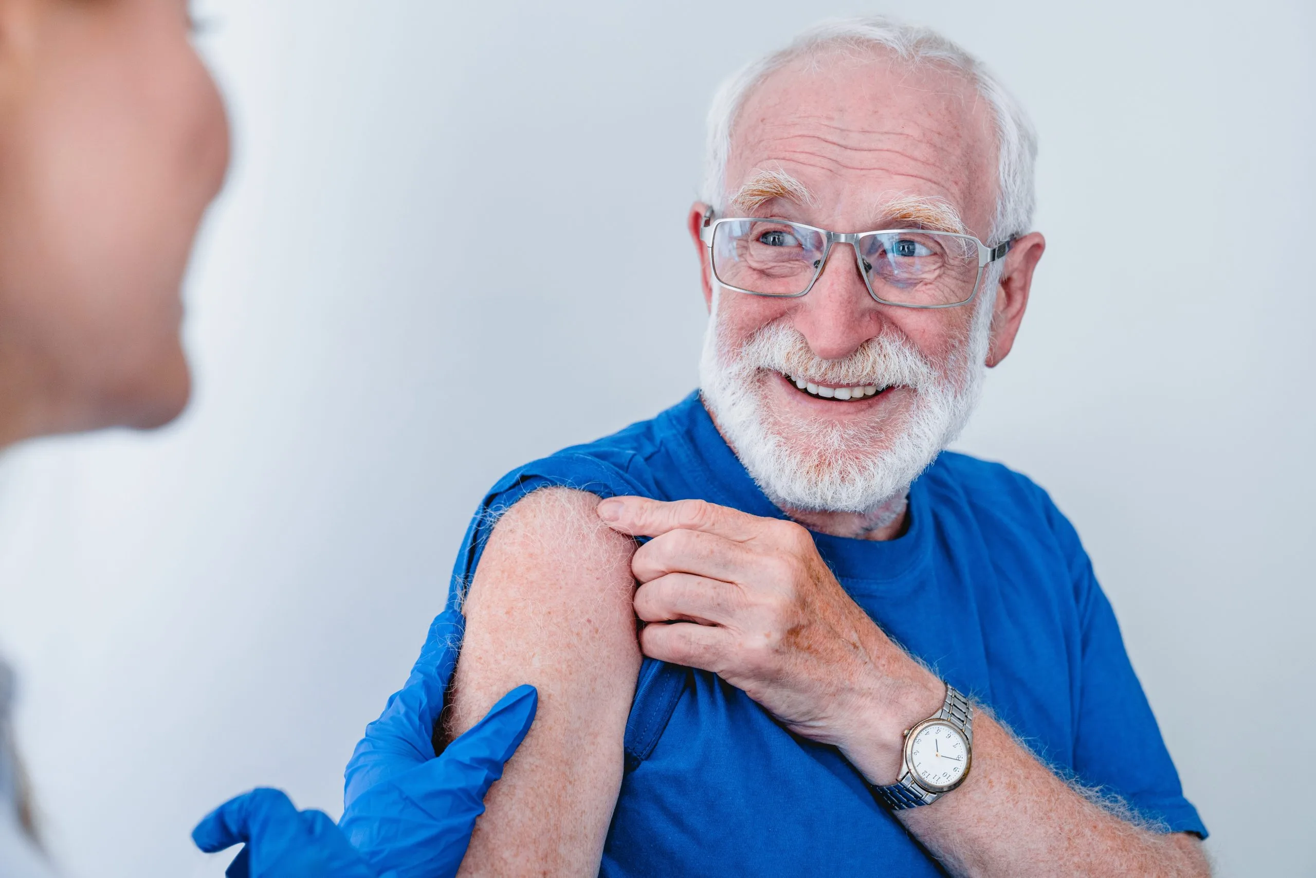 Man in blue tshirt about to get his vaccination