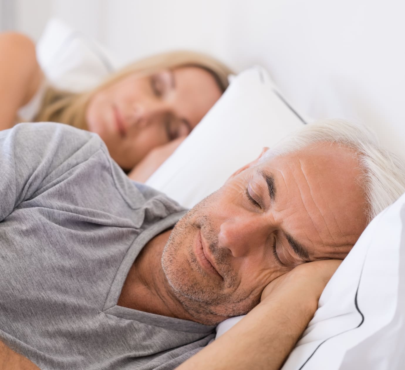 Senior man and woman sleeping. Senior man and woman resting with eyes closed. Mature couple sleeping together in their bed.