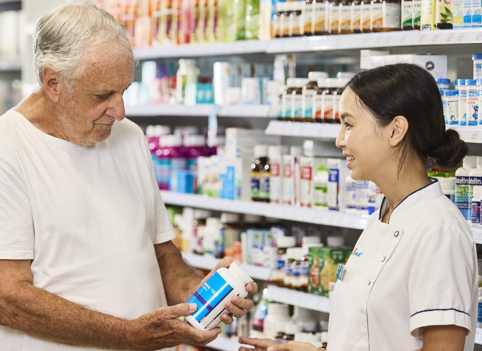 Amcal pharmacist is talking with customer