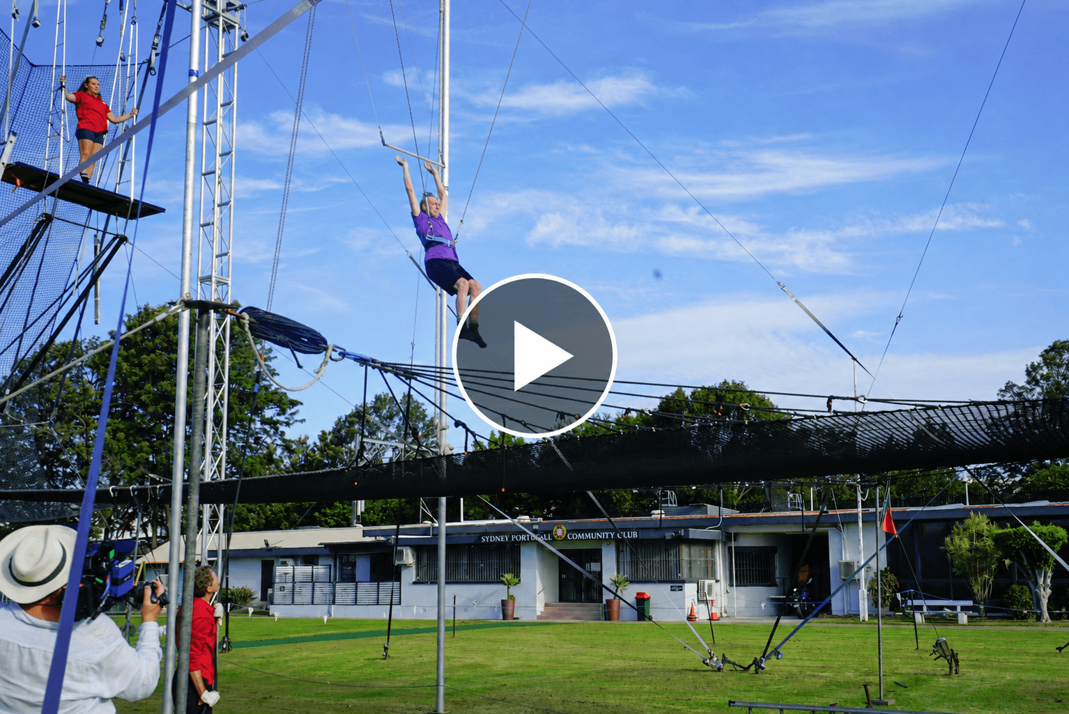 Trapeze scene with centered play button